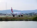 Samolot Czech Airlines na pasie startowym lotniska na Korfu, z wodą i zielenią w tle.
