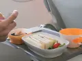 Na tacy w samolocie kanapki, deser i napój. Czy w bagażu podręcznym można mieć jedzenie? Tak, jak widać na zdjęciu.
