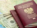 Dwa polskie paszporty i banknoty dolarowe na mapie. Planujesz podróż? Sprawdź, czy do Serbii potrzebny jest paszport.