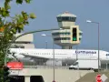 Lufthansa samolot na tle wieży kontroli lotów. To największe lotnisko w Europie, gdzie ruch jest zawsze intensywny.