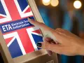 Dłoń dotyka ekranu z flagą Wielkiej Brytanii i napisem "ETA Electronic Travel Authorization".