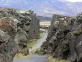 Wąwóz w Parku Narodowym Þingvellir, część Złotego Kręgu Islandii. Kamienne ściany i droga wiodąca w głąb krajobrazu.