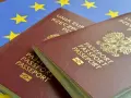 Dwa polskie paszporty na tle flagi Unii Europejskiej.