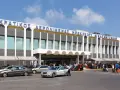 Lotnisko na Krecie, Heraklion N. Kazantzakis. Ludzie z bagażami czekają na transport przed nowoczesnym budynkiem terminalu.