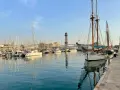 Port w Barcelonie, pełen żaglówek i statków, z wieżą widokową w tle. Czy w Barcelonie jest bezpiecznie? Tak, to spokojne miejsce.