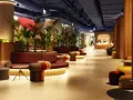 Nowoczesne wnętrze z roślinnością i kolorowymi meblami. Recepcja hotelu Mercure Warszawa Centrum wita gości.