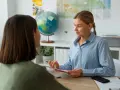 Doradca w biurze podróży pomaga klientce zaplanować wymarzoną podróż. To najlepsze biuro podróży w Polsce!