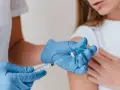 Rękawiczki medyczne, strzykawka i fiolka z lekiem. Przygotowanie do szczepienia w Malezji.