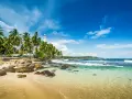 Tropikalna plaża na Sri Lance z latarnią morską i palmami. Po szczepieniach można tu bezpiecznie podróżować.