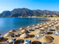 Piękna plaża z leżakami i parasolami, idealna na wycieczki dla samotnych seniorów.