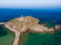 Portara, brama starożytnej świątyni Apollina, na skalistej wysepce. Największa wyspa Cyklad, Naksos, wita turystów.