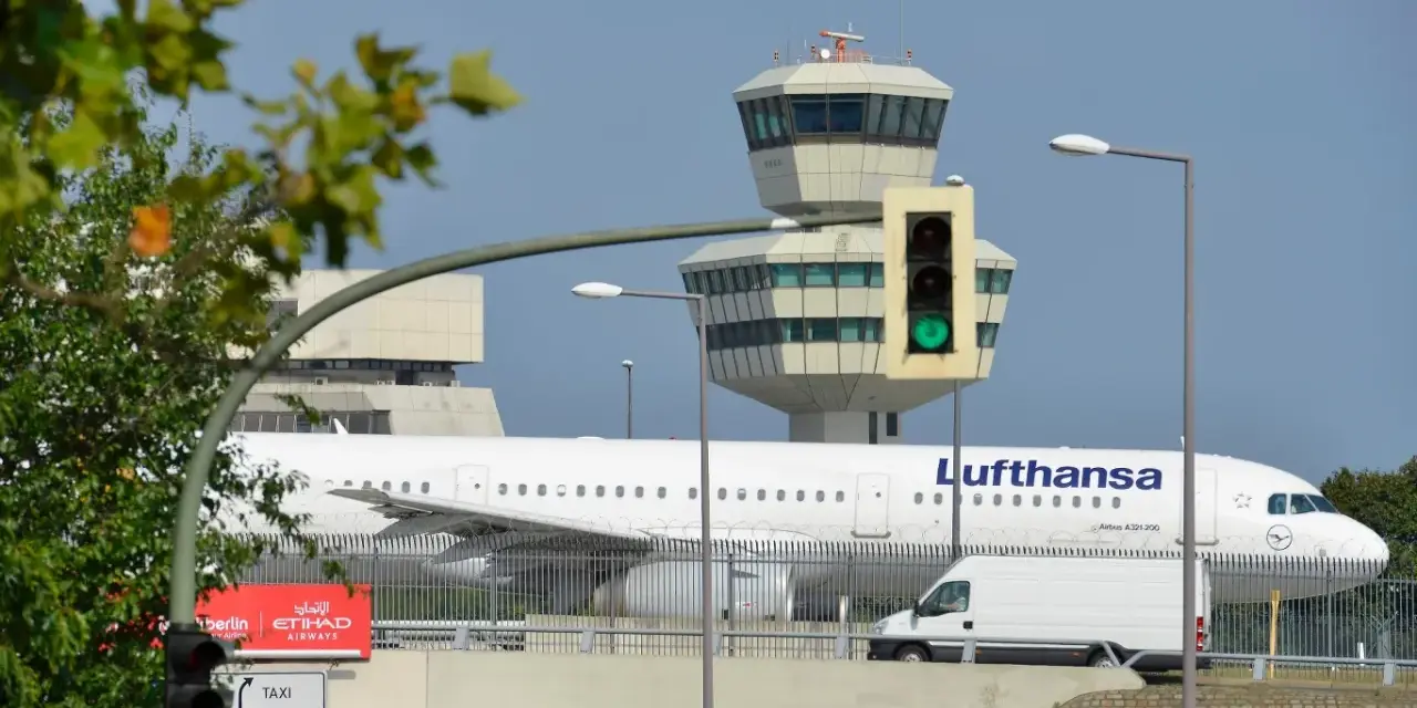 Lufthansa samolot na tle wieży kontroli lotów. To największe lotnisko w Europie, gdzie ruch jest zawsze intensywny.