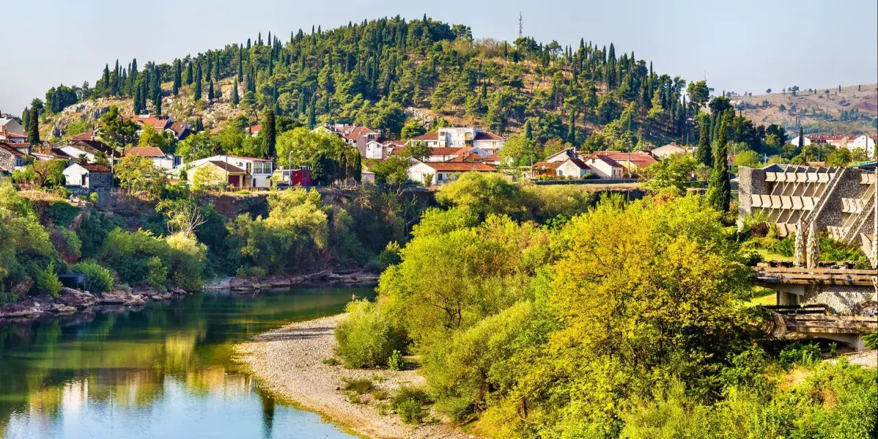 Malowniczy widok na miasteczko w Czarnogórze nad rzeką. Marzysz o bezpośrednie loty do Czarnogóry?