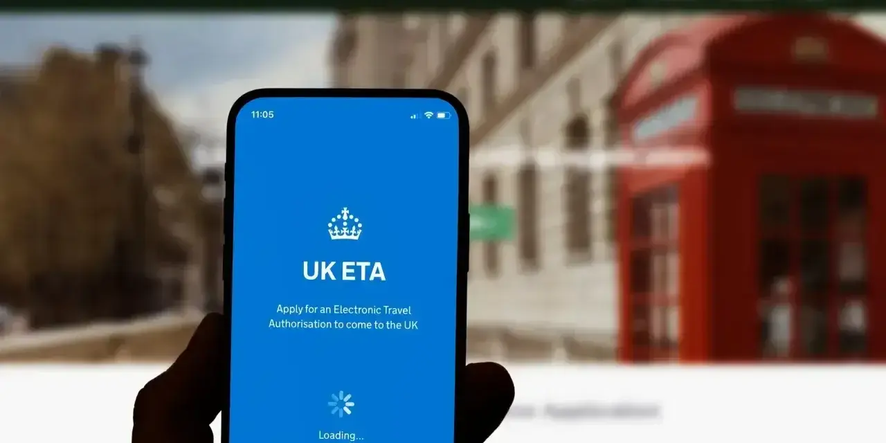 Dłoń trzyma smartfon z aplikacją UK ETA, która ułatwia uzyskanie zezwolenia na podróż do Wielkiej Brytanii.
