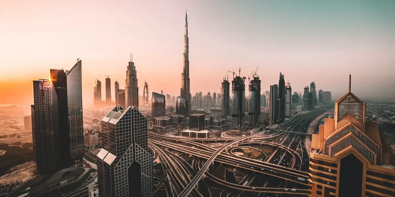 Zachód słońca nad Dubajem, z drapaczami chmur i skomplikowanymi węzłami drogowymi. Czy w Dubaju jest bezpiecznie? Tak, to nowoczesne miasto oferuje spokój.