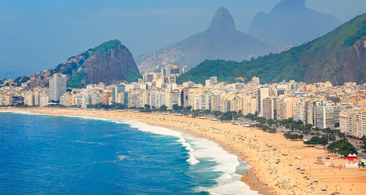 Copacabana w Rio de Janeiro, z tłumem na plaży i górami w tle. Czy do Brazylii potrzebna jest wiza? Sprawdź przed podróżą!