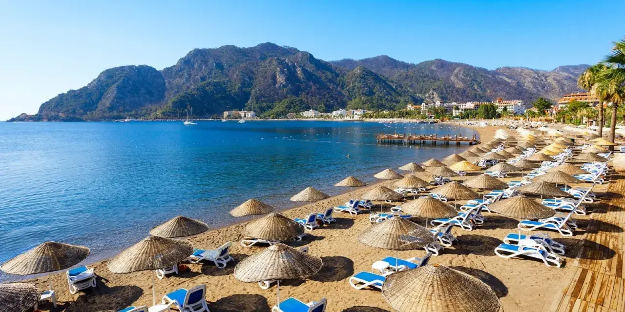 Piękna plaża z leżakami i parasolami, idealna na wycieczki dla samotnych seniorów.