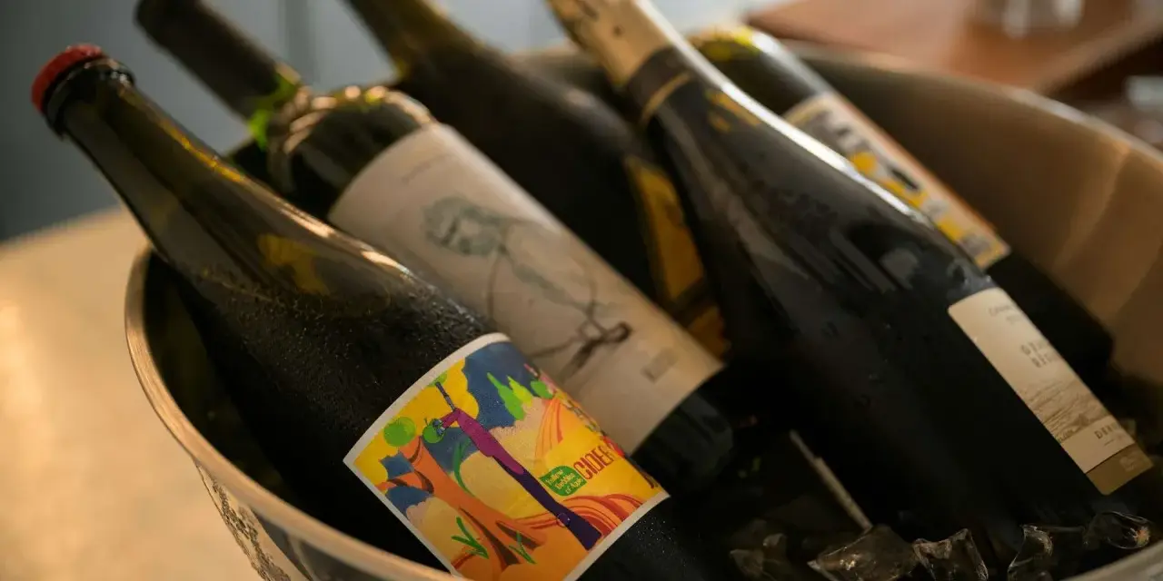 Butelki z napojami w wiaderku z lodem. Zastanawiasz się, czy można przewozić alkohol w bagażu rejestrowanym? Sprawdź przepisy!