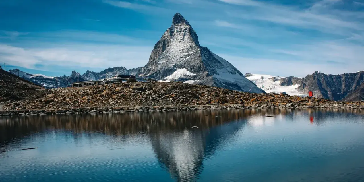 Majestatyczny Matterhorn odbija się w spokojnym jeziorze. Czy Szwajcaria jest w Schengen? Tak, podróżni mogą swobodnie przekraczać granice.