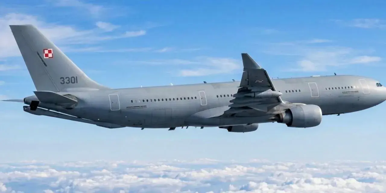 Szary samolot Airbus A330-300 z numerem 3301 i polską szachownicą na ogonie leci nad chmurami.