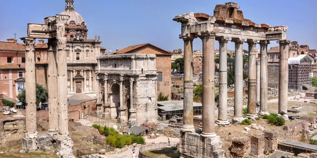 Wspaniały wyjazd do Rzymu! Ruiny Forum Romanum z łukiem i kolumnami na tle błękitnego nieba.