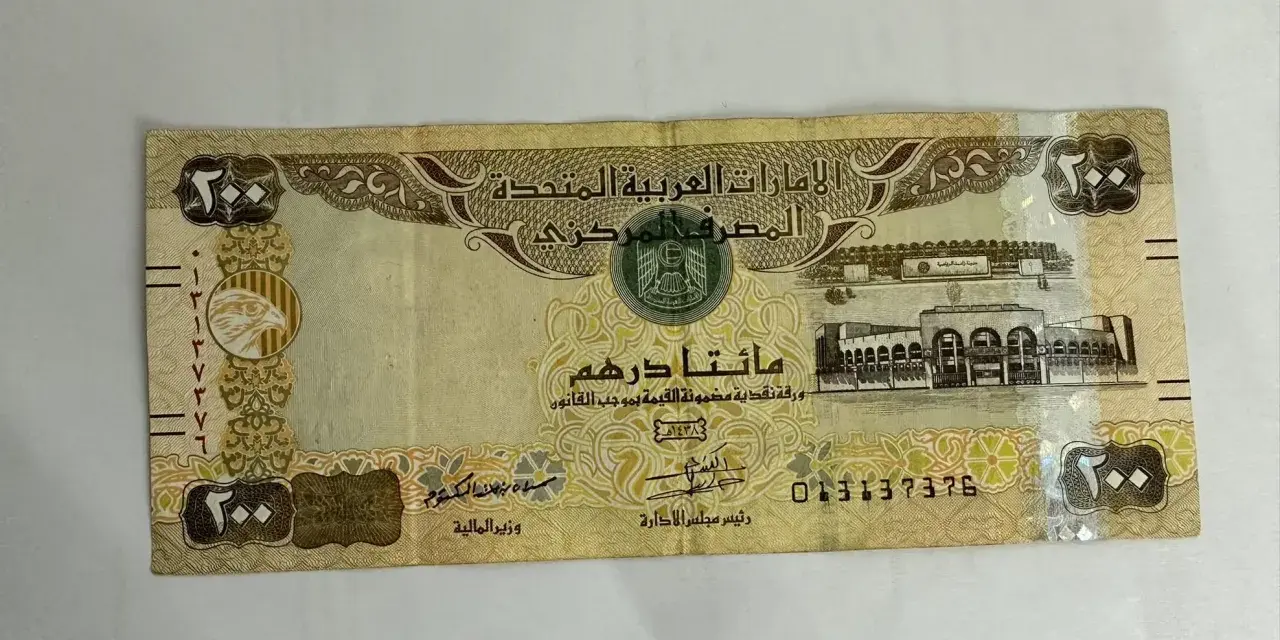 Banknot 200 dirhamów Zjednoczonych Emiratów Arabskich. AED jaka to waluta, widzimy orła i budynek.