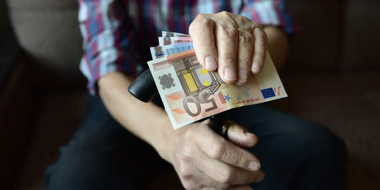 Dłoń trzyma banknoty euro, które są walutą Słowenii.