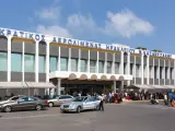 Lotnisko na Krecie, Heraklion N. Kazantzakis. Ludzie z bagażami czekają na transport przed nowoczesnym budynkiem terminalu.