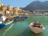 Port z łodziami rybackimi i domami na zboczu góry. Widok sugeruje, że na Sycylii jest bezpiecznie i spokojnie.