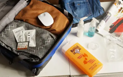 Pakowanie bagażu podręcznego: kosmetyki, ubrania i małe **płyny w bagażu podręcznym** w przezroczystej kosmetyczce.
