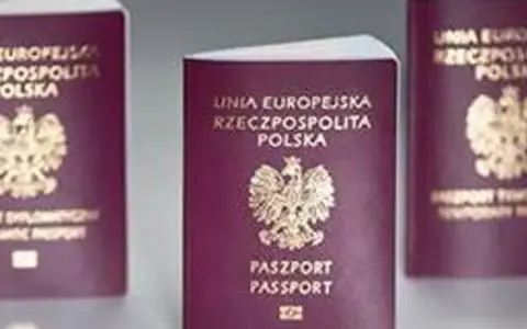 Trzy polskie paszporty w bordowych okładkach z godłem Polski.
