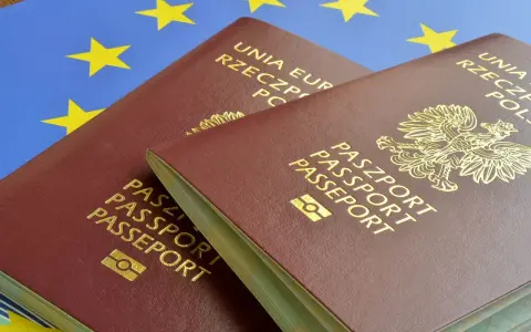 Dwa polskie paszporty na tle flagi Unii Europejskiej.