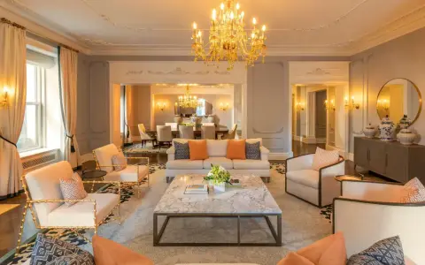 Elegancki salon z marmurowym stolikiem i złotym żyrandolem. Sprawdź hotel Plaza Nowy Jork ceny, by poczuć ten luksus.