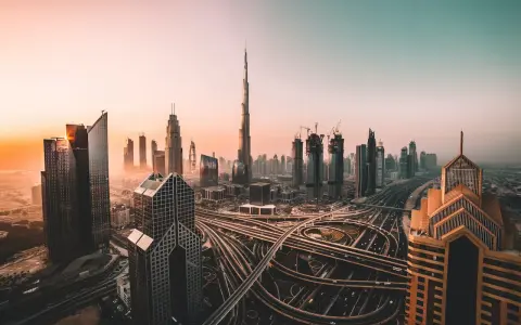 Zachód słońca nad Dubajem, z drapaczami chmur i skomplikowanymi węzłami drogowymi. Czy w Dubaju jest bezpiecznie? Tak, to nowoczesne miasto oferuje spokój.