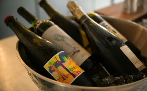 Butelki z napojami w wiaderku z lodem. Zastanawiasz się, czy można przewozić alkohol w bagażu rejestrowanym? Sprawdź przepisy!