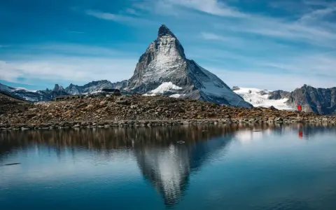 Majestatyczny Matterhorn odbija się w spokojnym jeziorze. Czy Szwajcaria jest w Schengen? Tak, podróżni mogą swobodnie przekraczać granice.