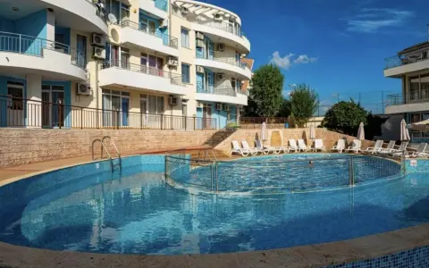 Słoneczna plaża w Bułgarii: basen z leżakami i hotel w tle, idealne miejsce na wakacje.