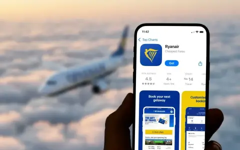 Ręka trzyma smartfon z aplikacją Ryanair, gotową do odprawy online. W tle leci samolot.