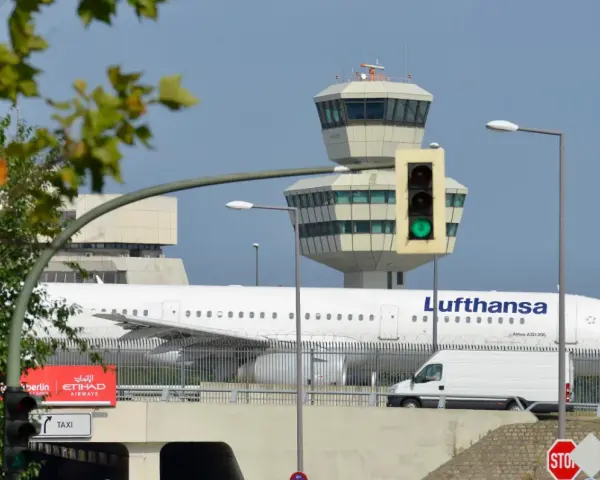 Lufthansa samolot na tle wieży kontroli lotów. To największe lotnisko w Europie, gdzie ruch jest zawsze intensywny.
