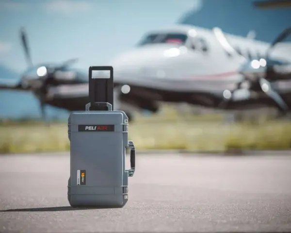 Szara walizka Peli Air na lotnisku, gotowa na lot czarterowy.