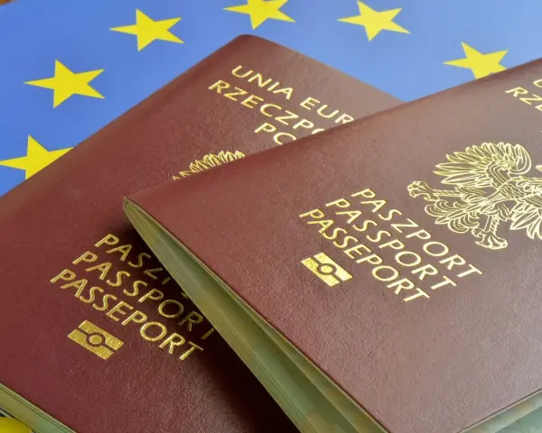 Dwa polskie paszporty na tle flagi Unii Europejskiej.