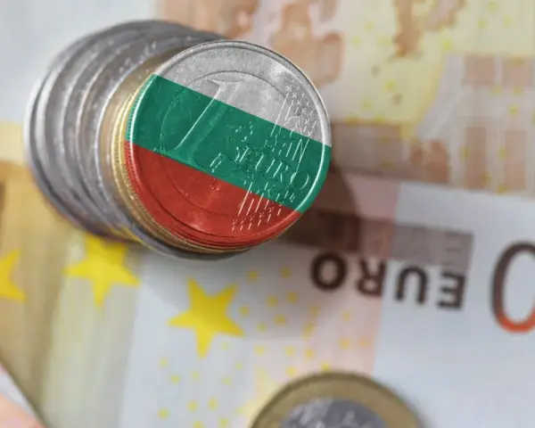 Monety z flagą Bułgarii leżą na banknotach euro. Waluta Bułgarii, lew, obok euro.