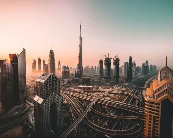 Zachód słońca nad Dubajem, z drapaczami chmur i skomplikowanymi węzłami drogowymi. Czy w Dubaju jest bezpiecznie? Tak, to nowoczesne miasto oferuje spokój.