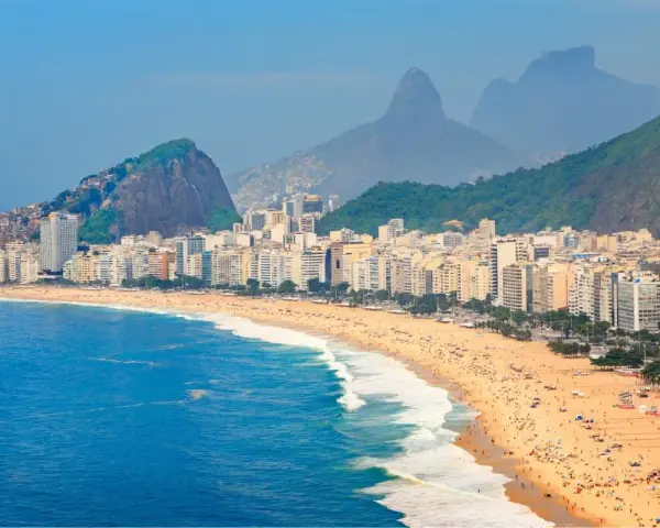 Copacabana w Rio de Janeiro, z tłumem na plaży i górami w tle. Czy do Brazylii potrzebna jest wiza? Sprawdź przed podróżą!
