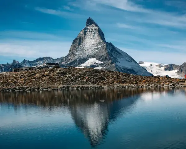 Majestatyczny Matterhorn odbija się w spokojnym jeziorze. Czy Szwajcaria jest w Schengen? Tak, podróżni mogą swobodnie przekraczać granice.