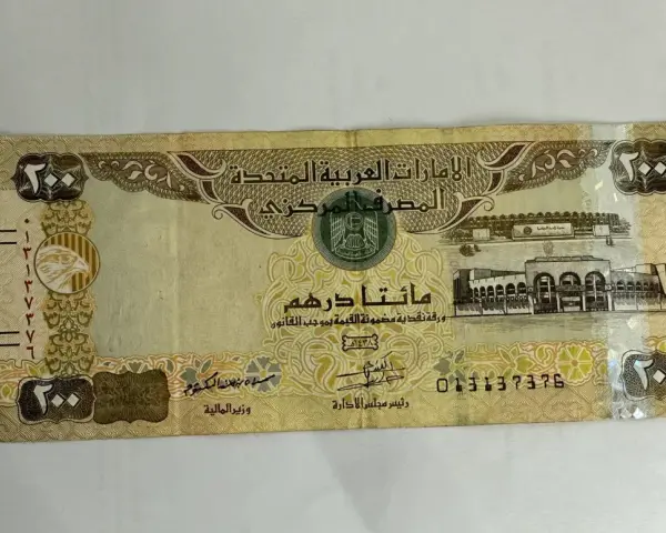 Banknot 200 dirhamów Zjednoczonych Emiratów Arabskich. AED jaka to waluta, widzimy orła i budynek.