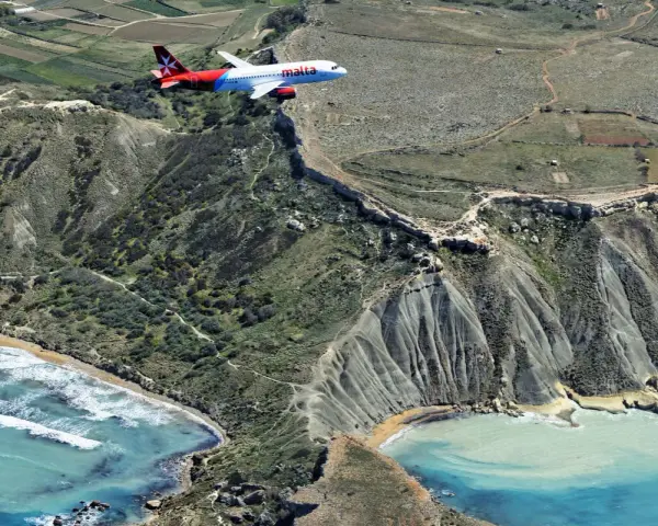 Samolot Malta Air przelatuje nisko nad klifami. Lotnisko Malta, niebezpieczne podejście do lądowania nad morzem.