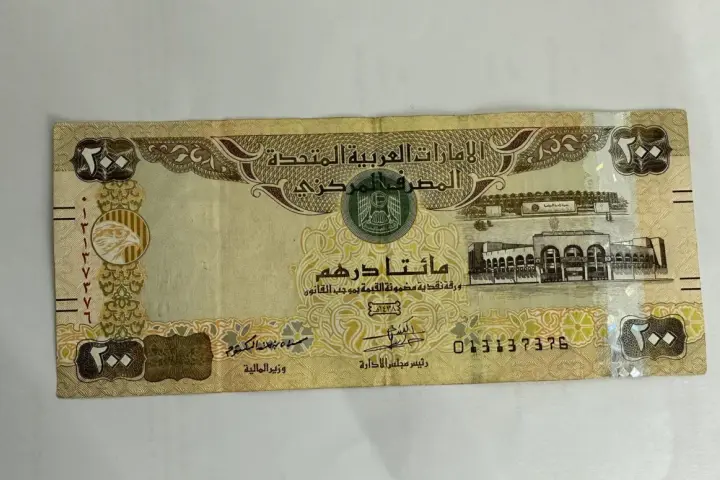 Banknot 200 dirhamów Zjednoczonych Emiratów Arabskich. AED jaka to waluta, widzimy orła i budynek.