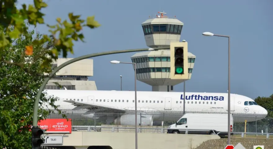Lufthansa samolot na tle wieży kontroli lotów. To największe lotnisko w Europie, gdzie ruch jest zawsze intensywny.