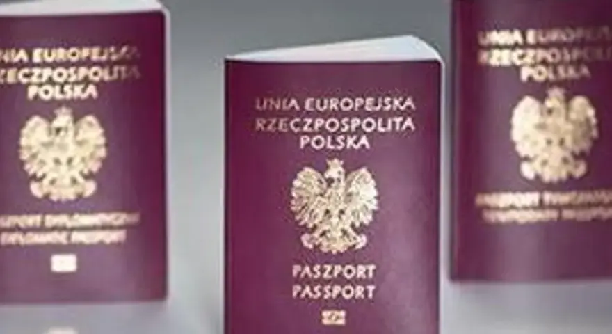 Trzy polskie paszporty w bordowych okładkach z godłem Polski.